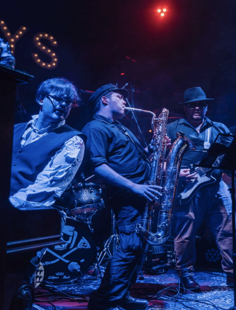 Man plays saxophone on stage at Leftys Bar