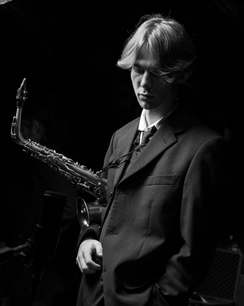 Chris James holding an alto saxophone